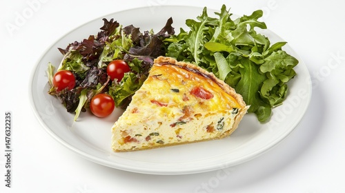 A slice of quiche served with a side salad on a white plate.