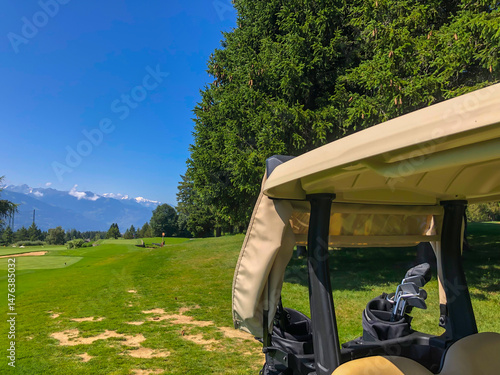 Golf Course with Mountain View and Golf Cart in Crans Montana in Valais, Switzerland.