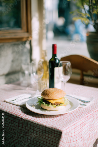 cozy restaurant scene featuring beautifully styled burger on bright tablecloth with retro utensils