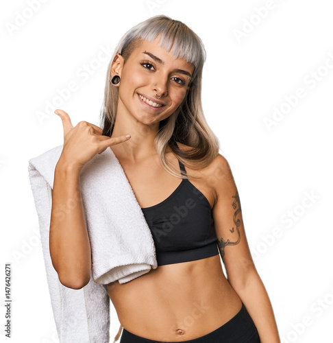 Caucasian young woman in sportswear showing a mobile phone call gesture with fingers.