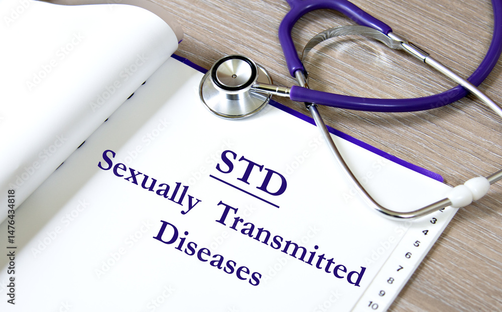 STD - acronym on a white sheet against the background of a stethoscope STD - acronym on a white sheet against the background of a stethoscope
