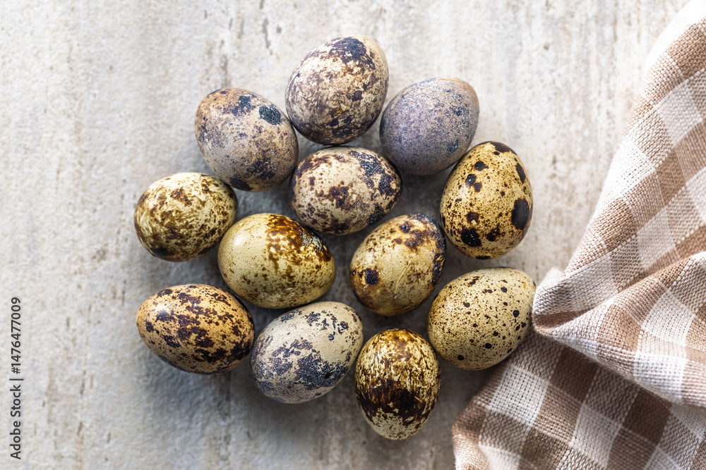 Spotted quail eggs on kitchen table. Top view.