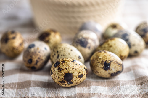 Spotted quail eggs on checkered tablecloth.