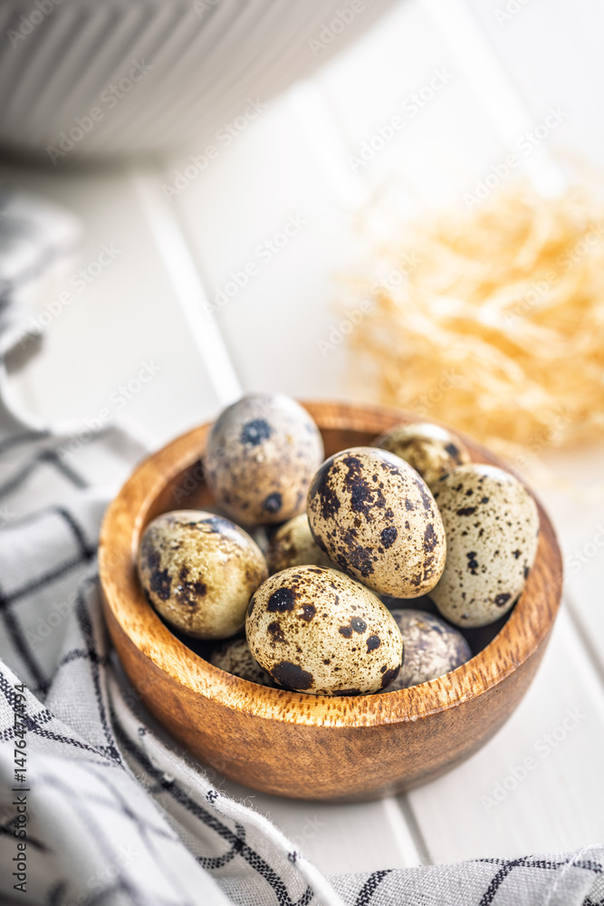 Spotted quail eggs in bowl on kitchen table.