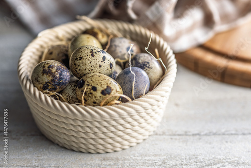 Obraz na płótnie Spotted quail eggs in bowl on kitchen table. w salonie