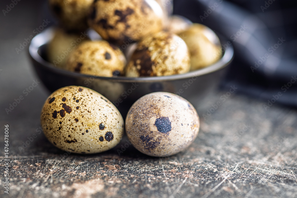 Spotted quail eggs on black table.