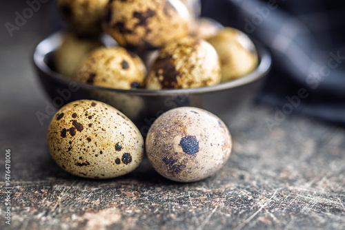 Spotted quail eggs on black table.