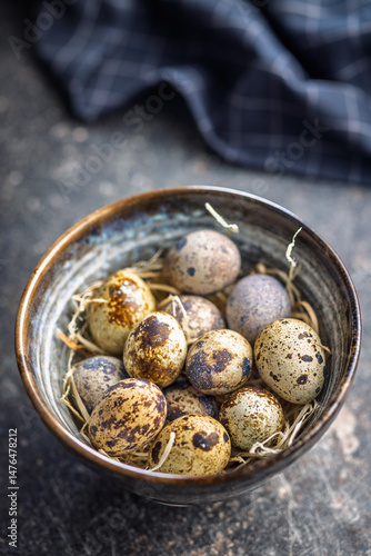 Obraz na płótnie Spotted quail eggs in bowl on black table. w salonie