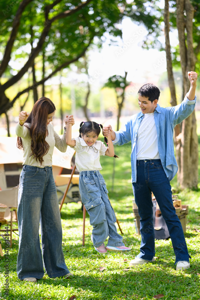 Obraz premium Happy family enjoying quality time together at a forest campsite with tents and picnic setup