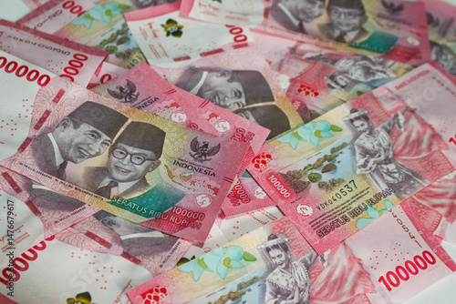 Indonesian Rupiah Currency. Stacks of 100,000 Rupiah banknotes depicting national heroes and traditional dancers, symbolizing wealth, economy, and cultural pride in Indonesian currency.