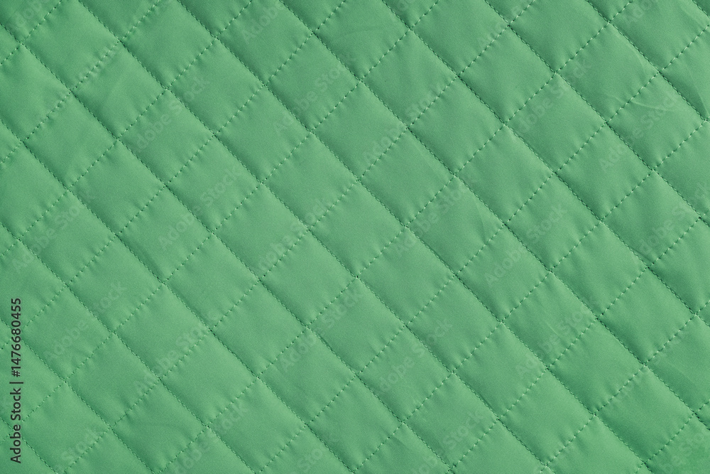 Fototapeta premium Checkered, diamond stitching pattern, green quilted fabric background. Blanket or puffer jacket, stitch rhombus texture close up, macro. Wallpaper, backdrop.
