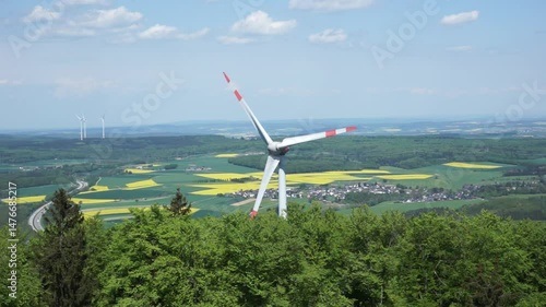 Wind Turbine Blades Rotating Against The Background of Fields and a Town