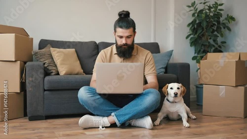 A young man with a laptop with her dog at home