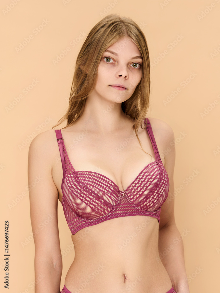 Obraz premium Girl model in underwear posing in studio on beige background.