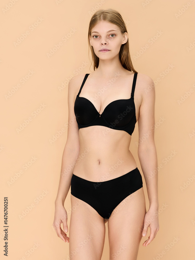 Girl model in underwear posing in studio on beige background. Girl model in underwear posing in studio on beige background.