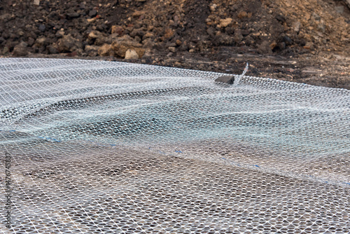 Groundwork preparation with geogrid wire mesh laid out on sub-soil surface for ground stabilisation and bearing capacity improvement