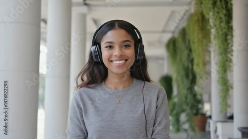 A young woman with headphones listens to music