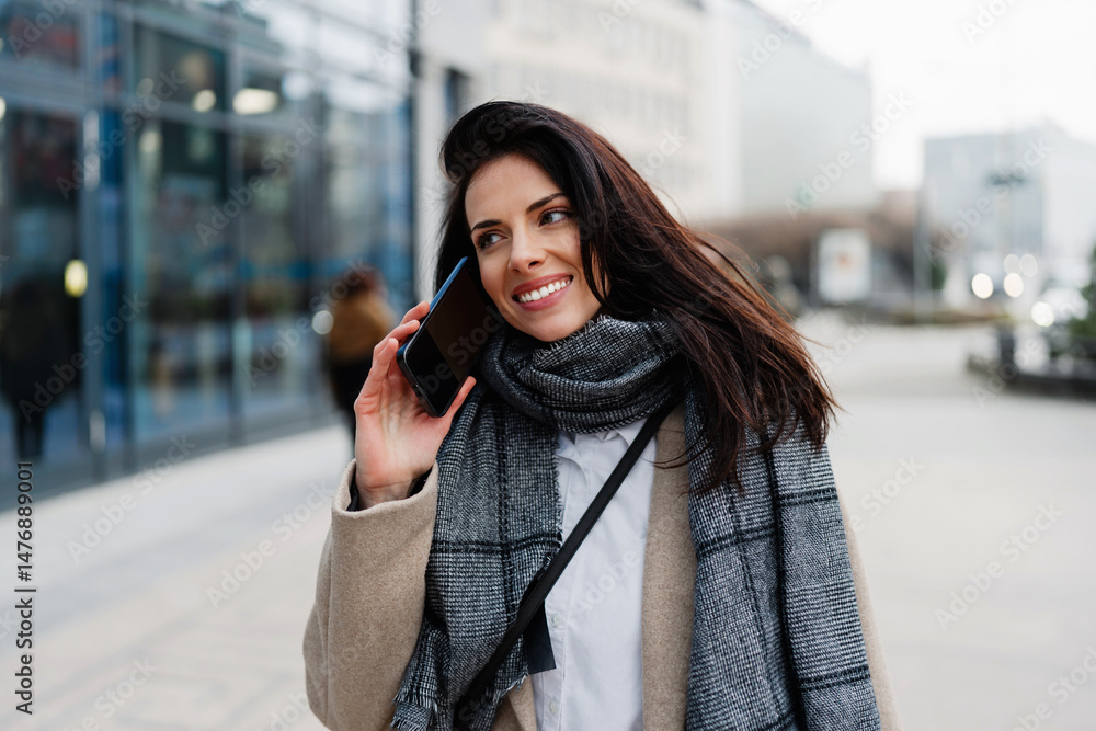 Smiling businesswoman in a stylish coat and scarf taking a selfie with her smartphone in front of a modern office building, enjoying urban connection and personal branding Smiling businesswoman in a stylish coat and scarf taking a selfie with her smartphone in front of a modern office building, enjoying urban connection and personal branding