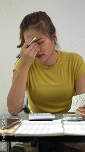 Young accountant feeling stressed and frustrated while counting banknotes
