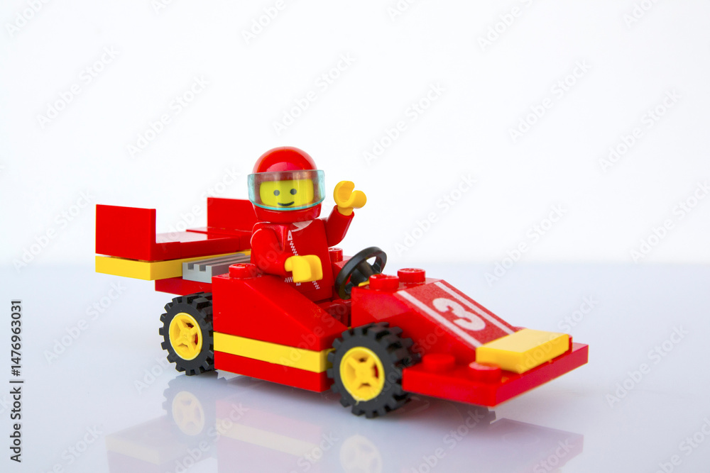 Fototapeta premium Coche de carreras rojo de LEGO oficial y piloto. Imagen aislada