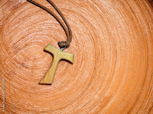 Foto Tau cross pendant resting on a terracotta surface