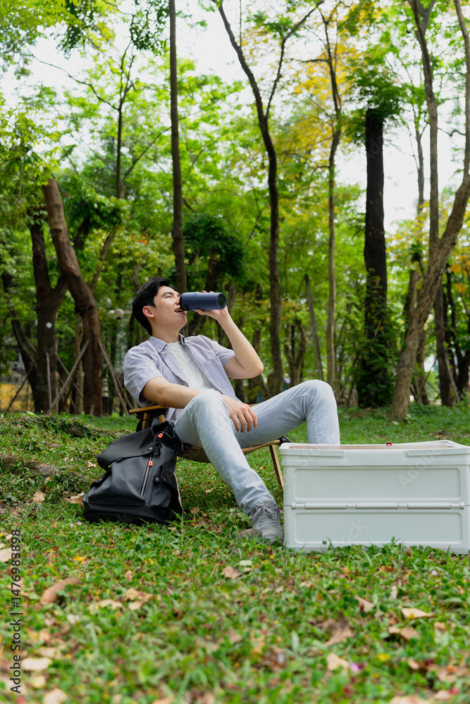 Fototapeta premium Relaxing in nature while enjoying a drink during a sunny day in the park