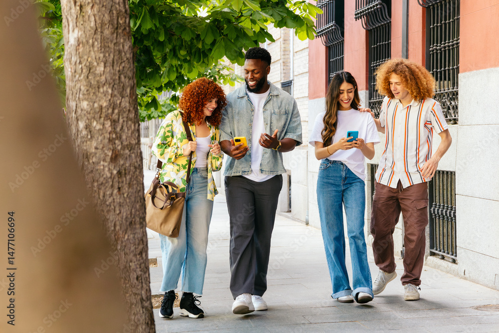 Fototapeta premium Multiethnic friends walking and using smartphones on the sidewalk