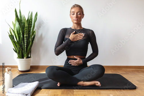 Tableau sur toile Calm woman using Pranayama breathing technique while practicing Yoga