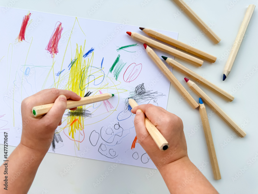 Child drawing with colorful pencils on white paper Child drawing with colorful pencils on white paper