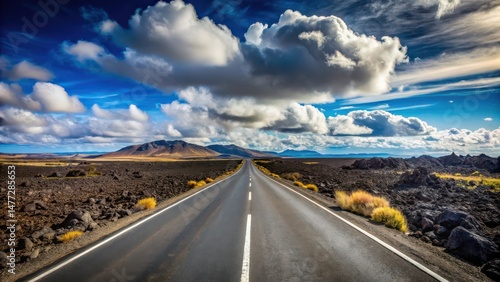 Fototapeta Naklejka Na Ścianę i Meble -  Asphalt ribbon cutting through a volcanic landscape under a dramatic sky, promising adventure and open horizons