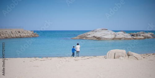 Two People Watching the Sea Together on a Calm Beach

