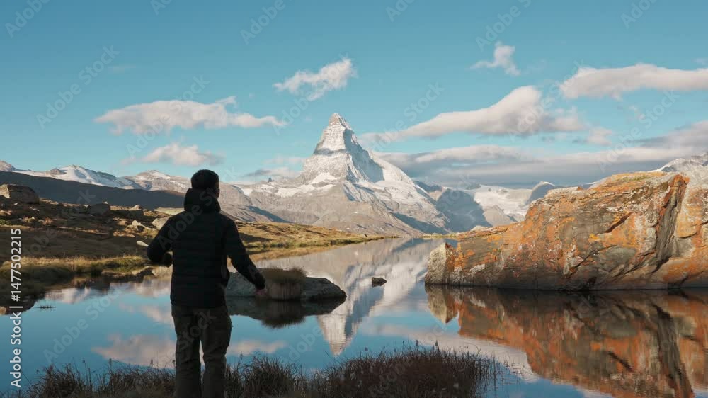 Traveler man standing and enjoying on Stellisee Lake with Matterhorn mountain in the morning at Switzerland