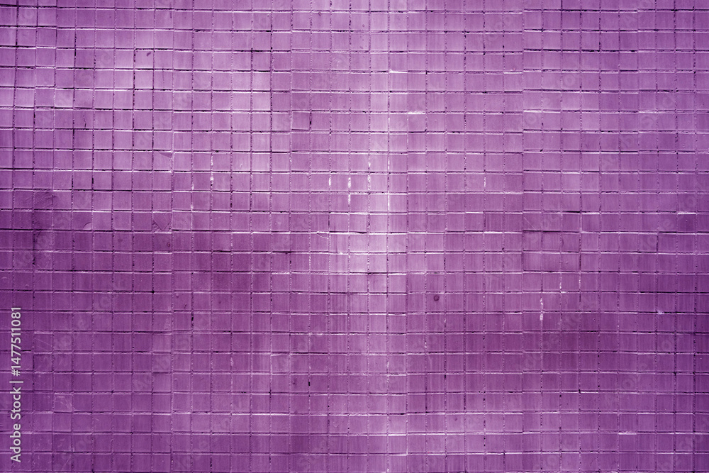 Fototapeta premium Grungy wall made of small purple square tiles.