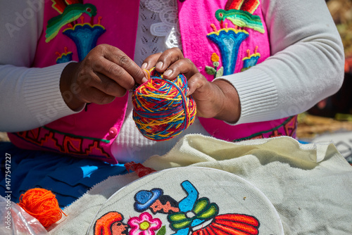 skillful Uros hands at work, delicately embroidering traditional Andean patterns. Each stitch reflects generations of cultural knowledge and artistic expression. Puno Peru