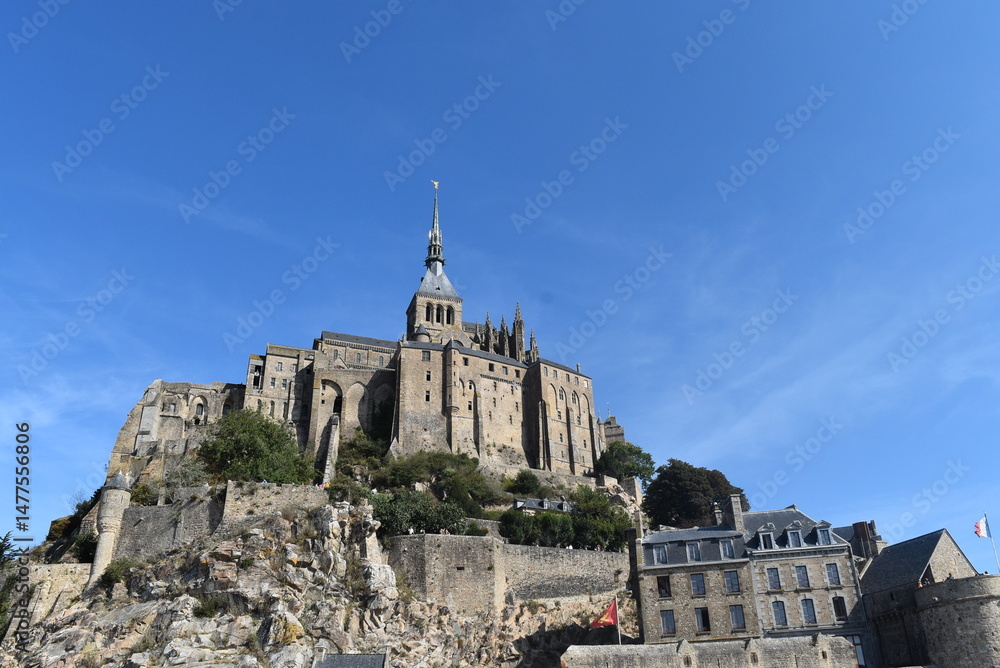 Obraz premium Vue en contre-plongée de l'abbaye du Mont Saint-Michel, située entre la Normandie et la Bretagne, en France. Ce monument historique très touristique est classé au patrimoine mondiale de l'UNESCO