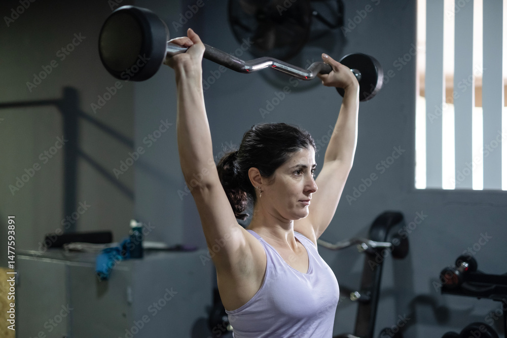 © FotoAndalucia - Woman in gym training with dumbbells © FotoAndalucia - Woman in gym training with dumbbells