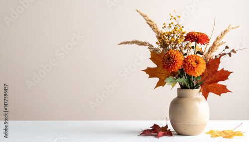 the image captures a vase filled with autumn themed floral elements against a neutral background