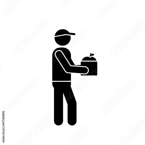Delivery person holding food container while standing in profile  