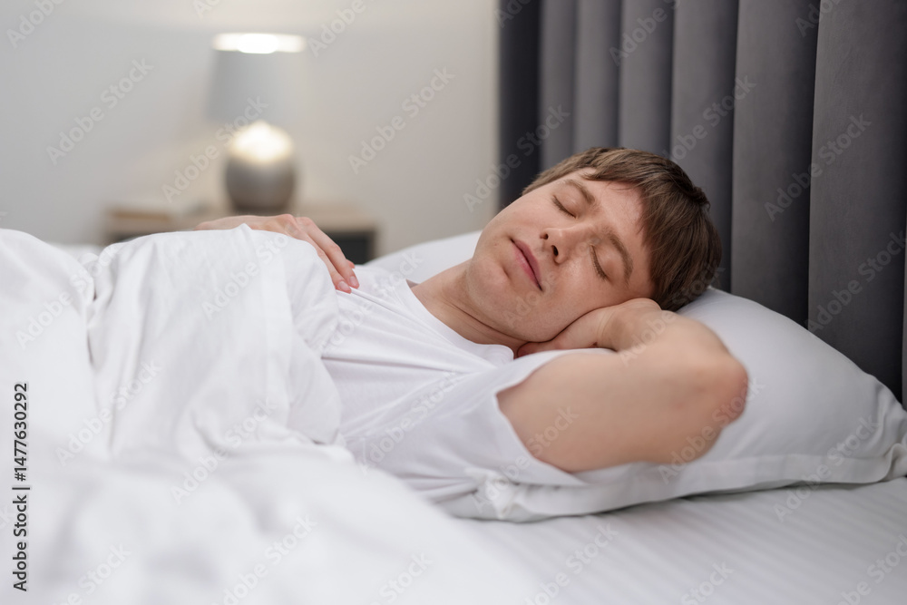 Young man sleeping in bed at home Young man sleeping in bed at home