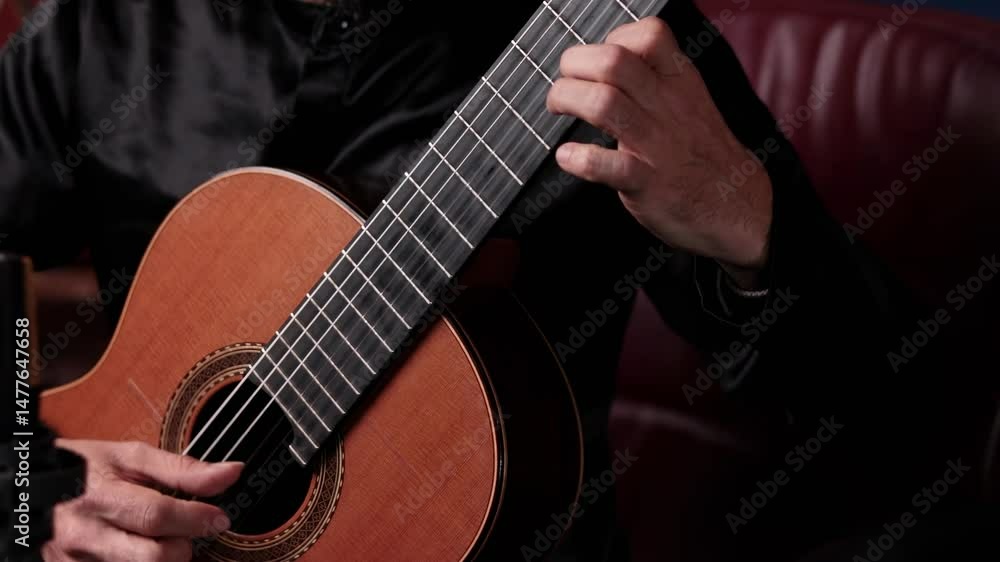 Close-up of a person playing a classical guitar, focusing on finger placement and technique. Close-up of a person playing a classical guitar, focusing on finger placement and technique.