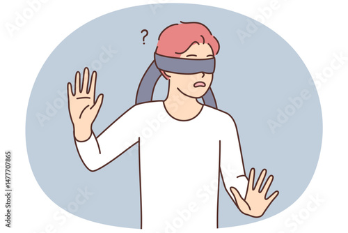 Frightened teen boy blindfolded trying to grope road of action in blind