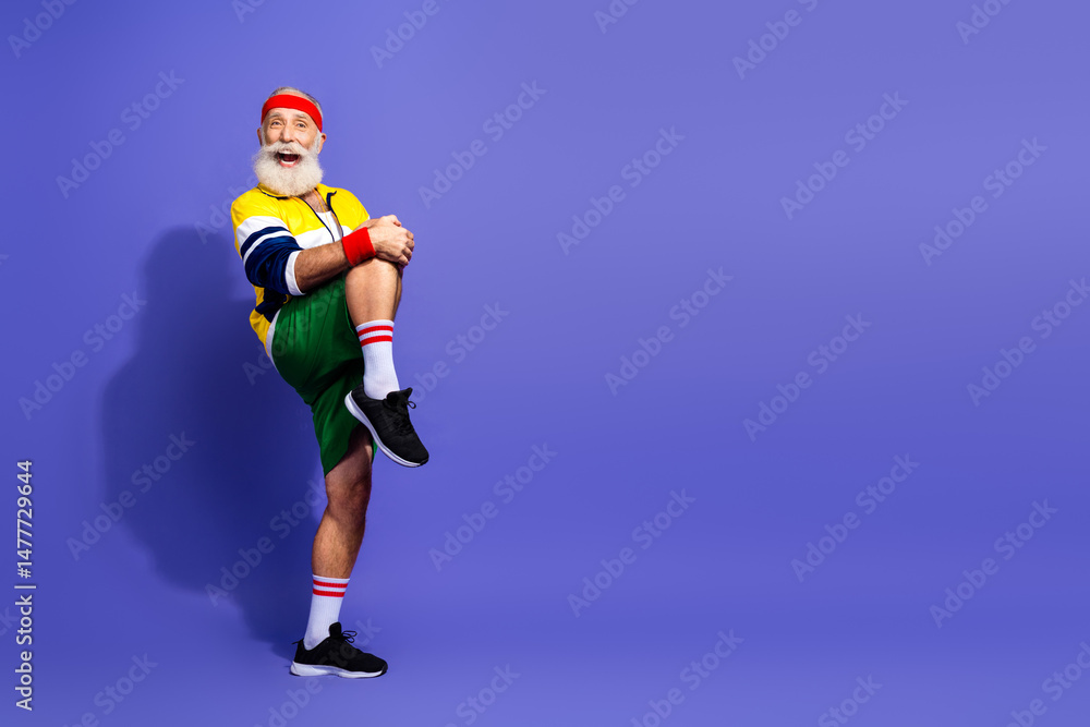 Obraz premium Elderly man in retro sports outfit enthusiastically performing a warmup exercise