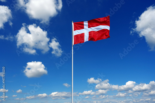 flag of Denmark fluttering in the blue sky with cumulus clouds
