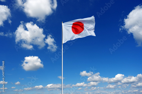 flag of Japan fluttering in the blue sky with cumulus clouds