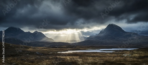 Sunlit Snow-Capped Mountains Under Dramatic Stormy Clouds photo