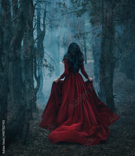 Art photo real person Gothic girl walking running in dark foggy forest trees, velvet red long medieval old style long dress train fly wind. Fantasy Woman Black hair back rear view fairy princess