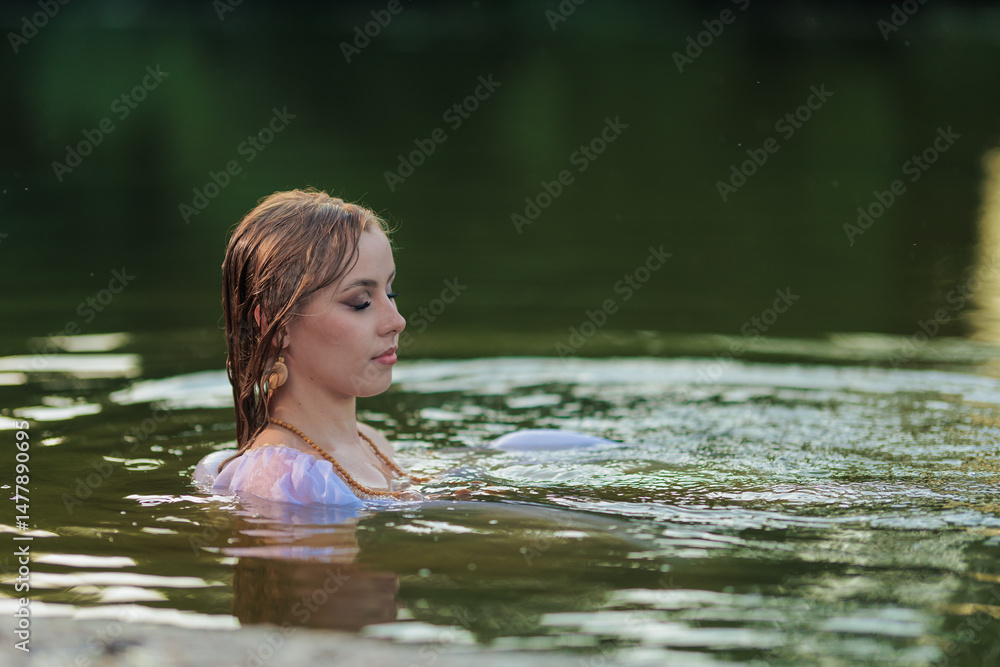 Fototapeta premium Beautiful Girl with long hair swims and dances in water