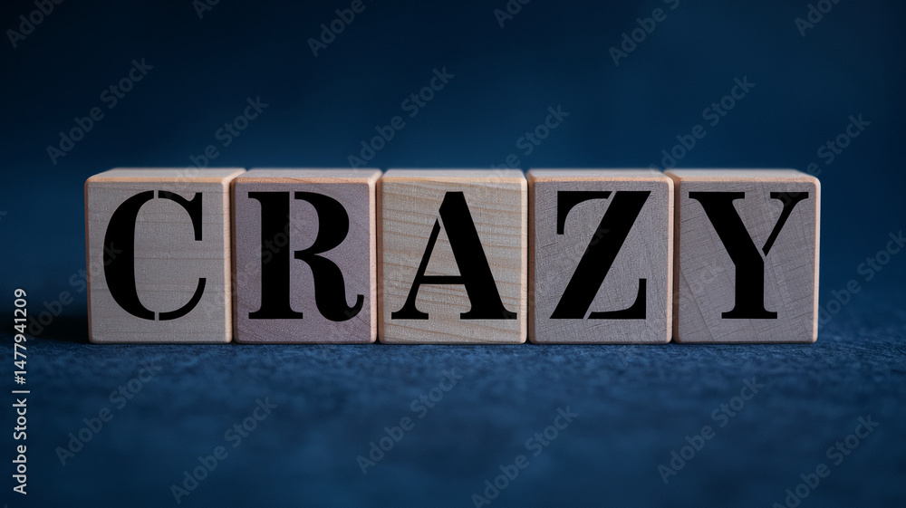 Fototapeta premium Wooden blocks spelling CRAZY on dark background, showcasing a concept of madness, excitement, or unpredictability