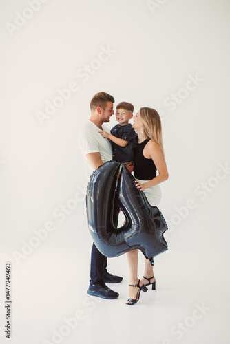 Obraz na płótnie A Heartwarming Family Celebration Enjoying Joyful Moments with a FourYearOld Birthday Boy Surrounded by Loving Parents in a Bright and Cheerful Studio Setting Filled with Balloons and Happiness w salonie