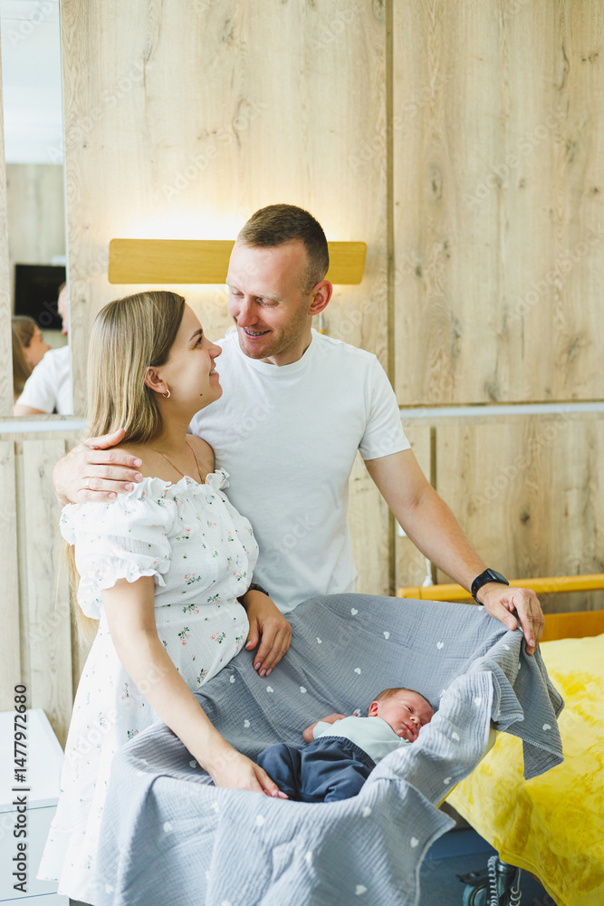 Joyful New Parents are admiring and cherishing their beautiful newborn in a cozy and inviting modern nursery, creating a peaceful atmosphere filled with love and warmth for their growing family